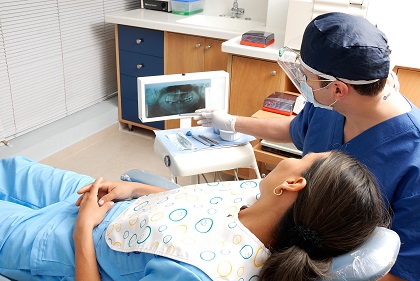 Zahnarzt und Patient sehen sich ein Röntgenbild an vor der Inlay Prozedur